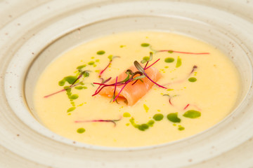 A bowl of creamy soup with salmon.