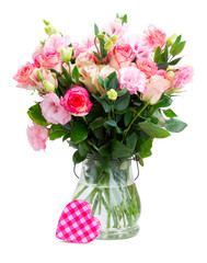 Rose and eustoma fresh flowers bouquet in two shades of pink in glass vase isolated on white background