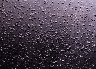 water drops on a black background with the reflection of light spots