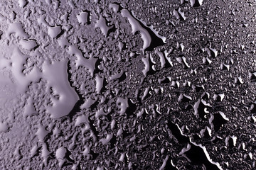 water drops on a black background with the reflection of light spots