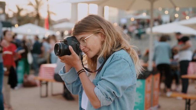 Young creative teenager, millennial hipster from generation z, makes photos on professional camera at event or festival. Concept summer job or internship, urban nomad freelancer