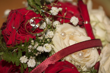 Ehe Ringe auf weißen und roten Rosen