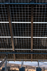 Close up of underside of solar panel installation in a dry landscape