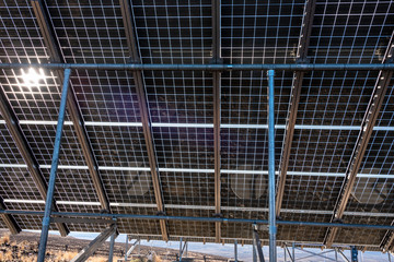 Close up of underside of solar panel installation in a dry landscape