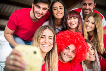 Football supporters at the stadium - Football fans having fun and looking at football match