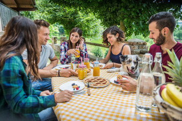 Group of friends having breakfast in a farmhouse