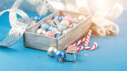 Fototapeta na wymiar Pink and blue Christmas balls and wrapping paper for gifts with old photo frame on wooden table