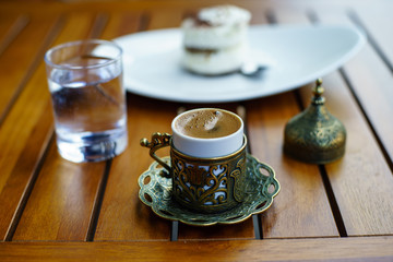 Turkish coffee with a glass of water and traditional copper serving set