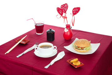 Table with served table with breakfast and drink, tablecloth red, cutlery.. Close up, indoor.