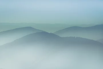 Photo sur Plexiglas Colline Paysage de collines montagneuses brumeuses. Vue des couches de montagnes et de brume dans les vallées. L& 39 effet de la teinture de couleur.