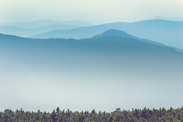 Misty mountain hills landscape. View of  layers of mountains and haze in the valleys. The effect of color tinting.