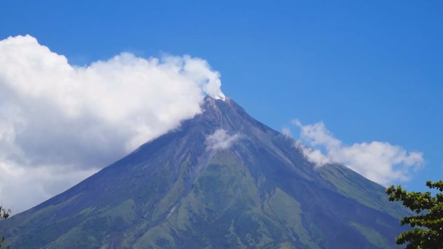 White ash clouds emit from Mayon volcano crater on a clear day