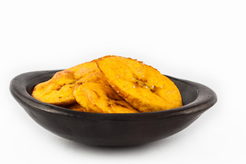 Fried half ripe plantain slices isolated on white background