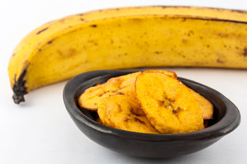 Fried half ripe plantain slices isolated on white background