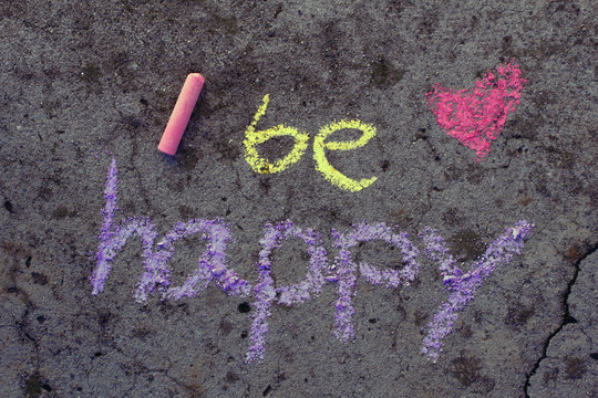 Colorful chalk drawing on asphalt: Words BE HAPPY