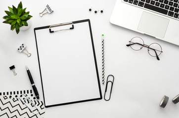 Clipboard mockup flat lay frame with laptop, notebook and accessories. Top view Home office workspace.