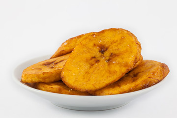 Fried half ripe plantain slices isolated on white background