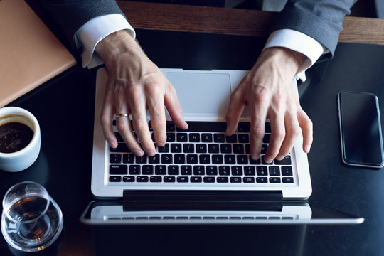 Business man using laptop computer. Male hand typing on laptop keyboard.