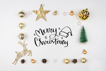 Christmas lettrering. Frame made of christmas decoration, christmas deer, balls, cones, golden star and fir tree. Flat lay, top view. Trendy greeting card