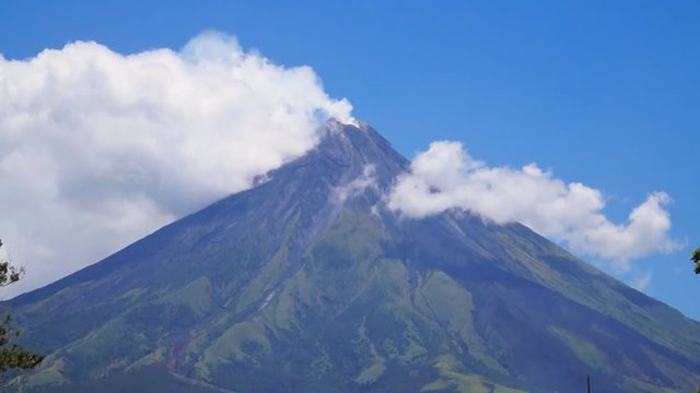 White ash clouds emit from Mayon volcano crater on a clear day