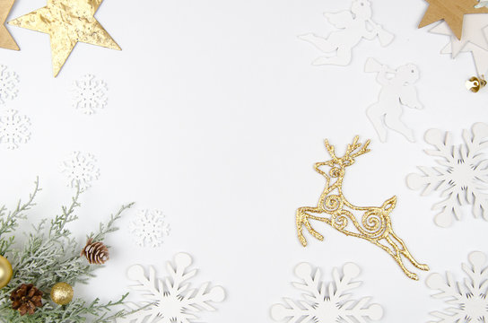 Christmas mockup flat lay styled scene with christmas decorations, angels, golden deer, stars and snowflakes . Copy space White wooden background