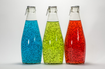 three bottles with colorful liquid and chia seeds