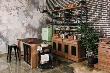 Dining area in industrial style with table, chairs and mint retro fridge. Black vintage brick wall...