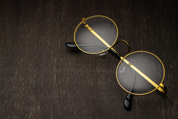 gold glasses on a dark wooden background