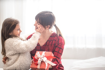 Christmas concept, the Daughter gives a gift to her mother