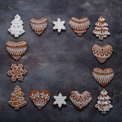 Gingerbread cookies frame on dark background. Snowflake, star, tree, top view copy space