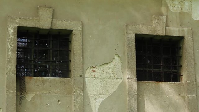 Slow motion window with lattice of an old in a stone house conceptual blockhouse cold frame frost glass outdoor strong close up