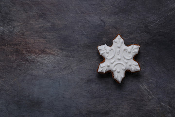 Fototapeta na wymiar Gingerbread cookies snowflake on dark background, copyspace