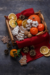 Christmas wooden box filled with gingerbread cookies, dry oranges, tangerines and nuts, copyspace