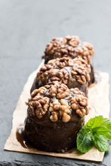 Sticky chocolate and walnut puddings on black stone background