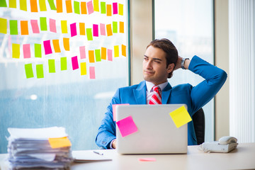 Young handsome employee with many conflicting priorities   