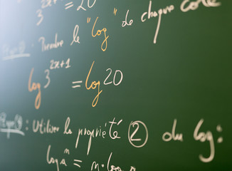 Mathematical formulae on a blackboard in a classroom.