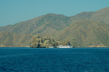 Obraz premium Recreation on the boat near the shore of a mountain. Ship on the water. summer vacation travelling