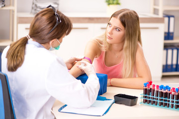 Obraz premium Young beautiful woman during blood test sampling procedure 