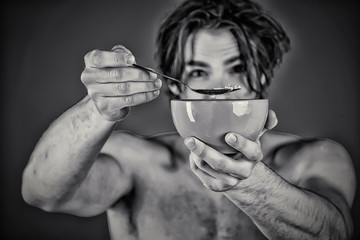 Guy with breakfast. Close up of young man feeding someone with spoon. Sharing food with others. Healthy lifetyle and habits. Breakfast in morning.