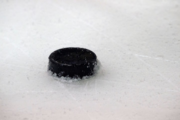 black hockey puck on ice rink. Winter sport.