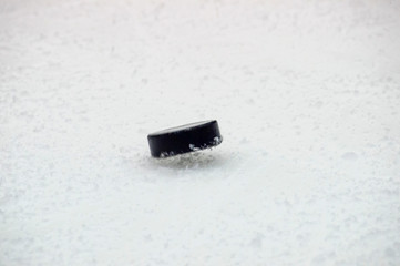 black hockey puck  jump on ice rink. Winter sport.