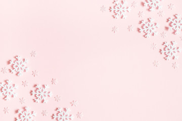 Christmas or winter composition. Frame made of snowflakes on pastel pink background. Christmas,...