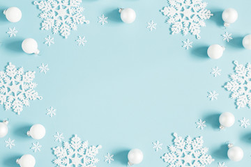 Christmas or winter composition. Pattern made of white balls and snowflakes on pastel blue...