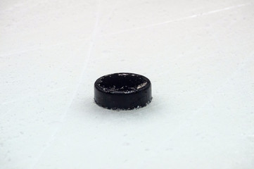 black hockey puck on ice rink. Winter sport.