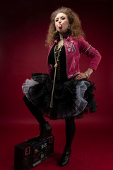 Girl, 1980's style with boom box and bubble gum. red backdrop