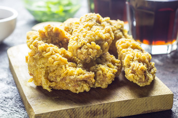 Fried chicken wings on wooden cutting board.