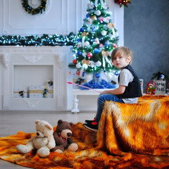 Ребенок ждет чуда в Новый год. С новым годом! Счастливого Рождества! Новогодняя елка с рождественскими игрушками. Мальчик с игрушками.
