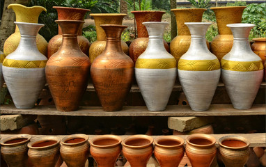 Fototapeta na wymiar Unique handmade colorful ceramic vases. Clay pots stacked for sale. Pottery making place. Local craft market. Craftsmanship.