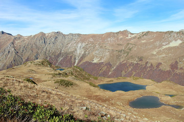 Panorama with yellow autumn hills, lakes and mountains. Abkhazia.