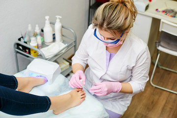 Pedicure in the beauty salon. Specialist performs work on foot care